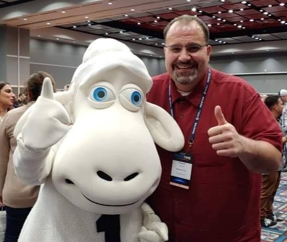 Owner of Mattress Folks in Mauldin SC giving thumbs up with mattress mascot at industry event